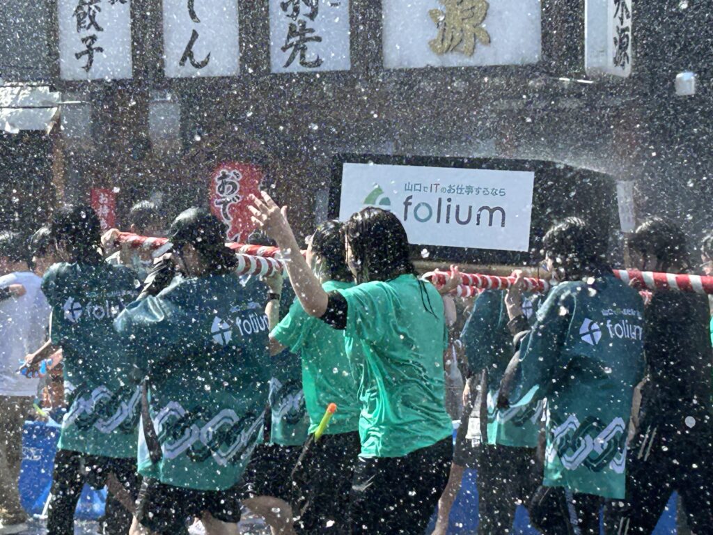 社名ロゴ入りの法被・Tシャツを着てお神輿を担ぐフォリウム社員