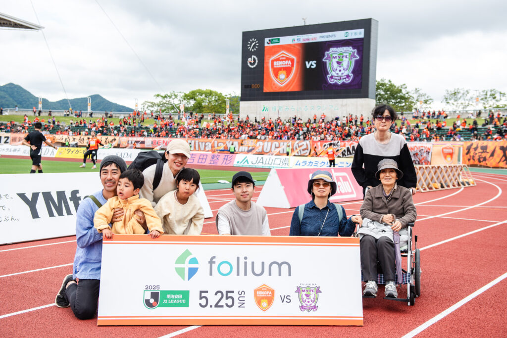 ピッチ内で記念撮影をするフォリウム社員とその家族