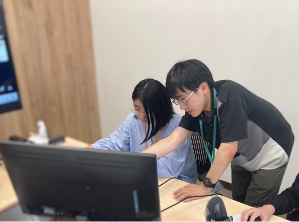 エンジニアのメンバーが学生にローコードツールの使用方法を説明する様子