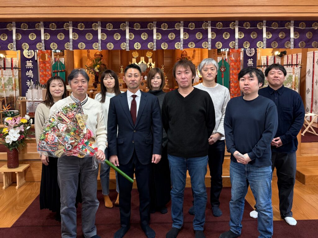 社殿内で記念撮影する取締役COO 田中（前列左から２番目）と幹部、マネージャー陣